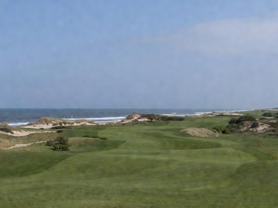 Coastal golf landscape under a muted blue sky